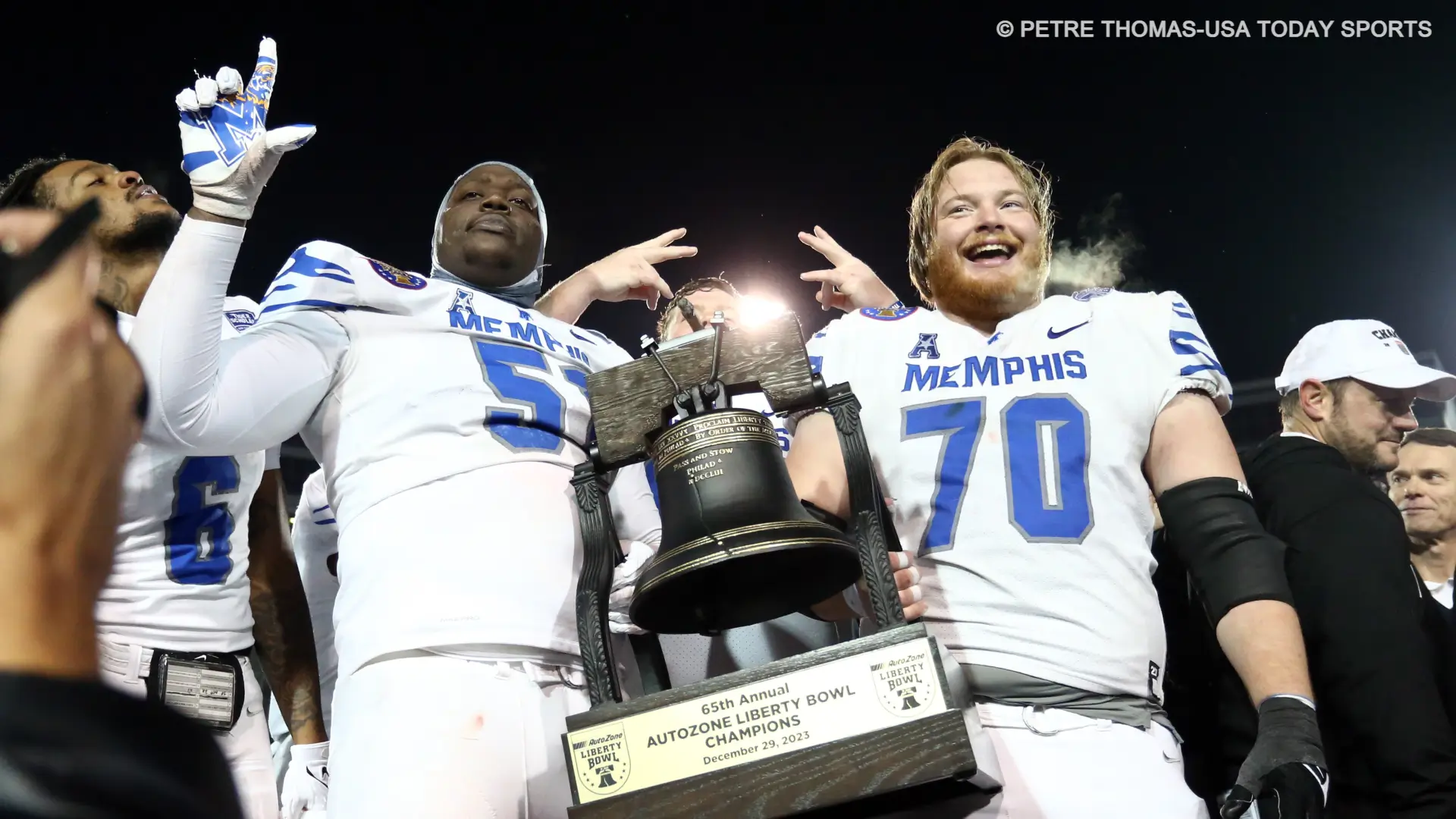 Memphis Tigers offensive linemen Terrance McClain (51) and Jacob Likes (70) hold Liberty Bowl trophy