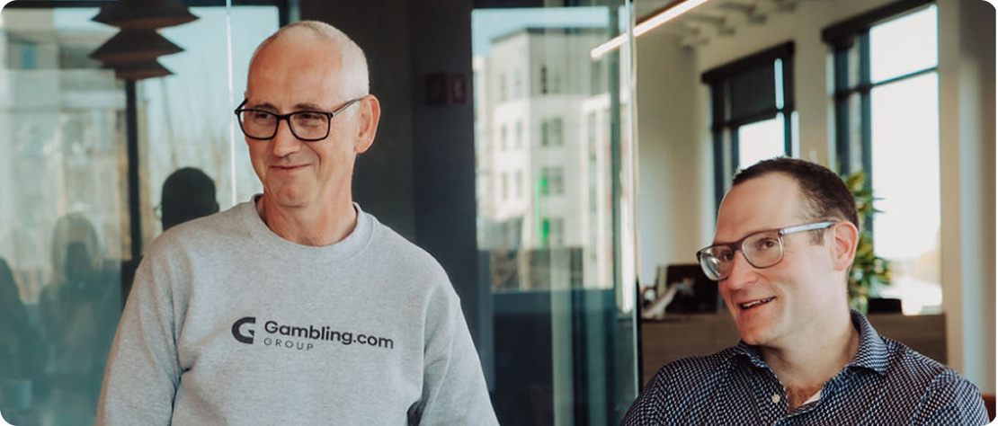 Gambling.com Group employees talking at conference table