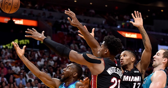 Charlotte Hornets guard Kemba Walker (15) is pressured by Miami Heat center Hassan Whiteside (21) and Miami Heat guard Rodney McGruder (17) during the second half at American Airlines Arena.