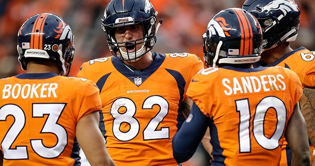 Denver Broncos tight end Jeff Heuerman (82) celebrates with running back Devontae Booker (23) and wide receiver Emmanuel Sanders (10) after a touchdown in the third quarter against the Houston Texans at Broncos Stadium at Mile High.