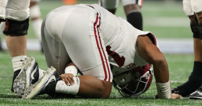 Alabama Crimson Tide quarterback Tua Tagovailoa (13) reacts to an apparent injury during the fourth quarter against the Georgia Bulldogs.