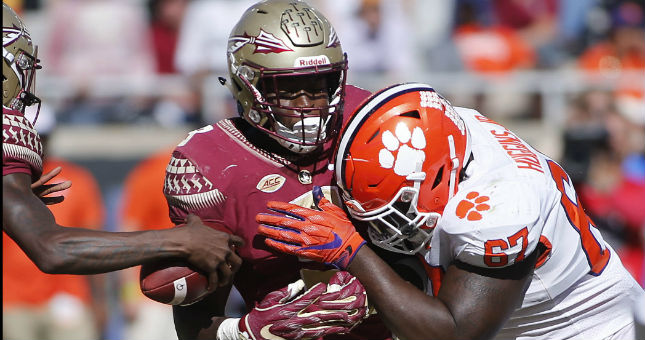 Florida State Seminoles running back Jacques Patrick (9) is drilled by Clemson Tigers defensive tackle Albert Huggins.