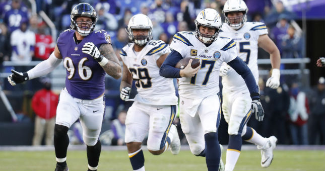 Chargers quarterback Philip Rivers (17) runs with the ball as Ravens defensive end Brent Urban (96) chases.