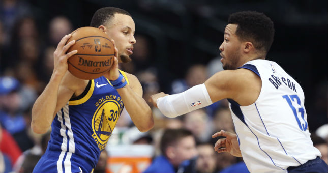 Warriors guard Stephen Curry (30) looks to pass as Mavericks guard Jalen Brunson (13) defends.