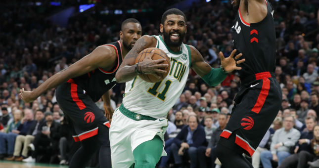 Celtics guard Kyrie Irving (11) drives the ball against Toronto Raptors forward Kawhi Leonard (2) and forward Serge Ibaka (9).