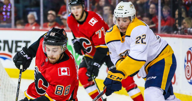 Flames left wing Andrew Mangiapane and Predators left wing Kevin Fiala battle for the puck.