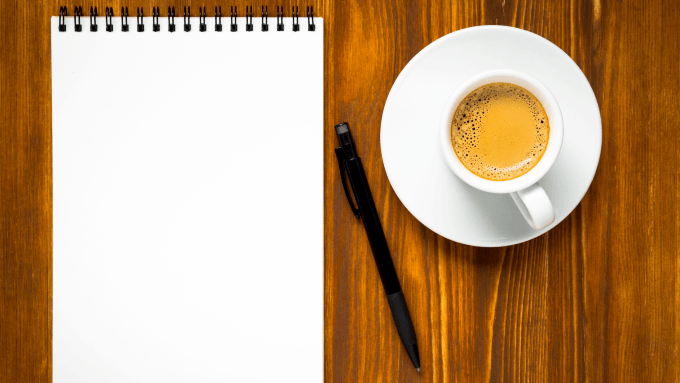 Hand schreibt in ein Notizbuch