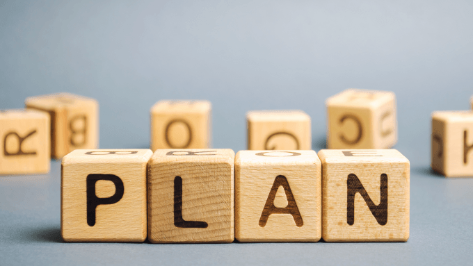 Holzwürfel mit Buchstaben zeigen das Wort Plan